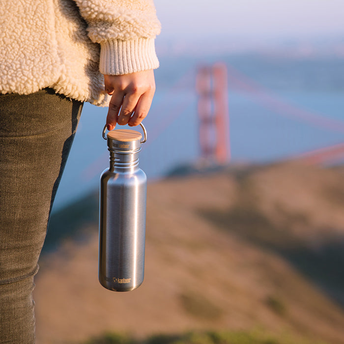 27oz-reflect-with-bamboo-cap-t1 K27SSLRF-BS-BAMBOO_reflect_bottle_bridge_lifestyle.jpg